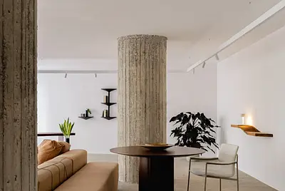 Colunas de concreto, piso bruto e paredes brancas no Edifício Itália