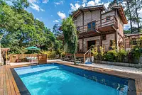 Casa com muitas árvores em condomínio fechado estilo rústico moderno 