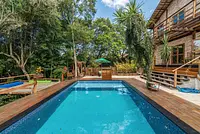 Casa com muitas árvores em condomínio fechado estilo rústico moderno 